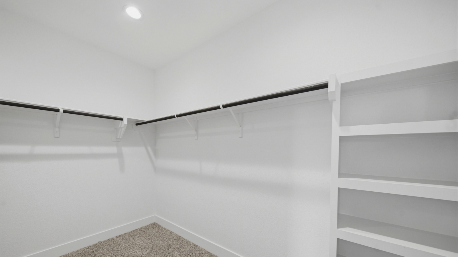 Primary bedroom walk-in closet with carpet flooring in Mill Creek community in Magnolia TX