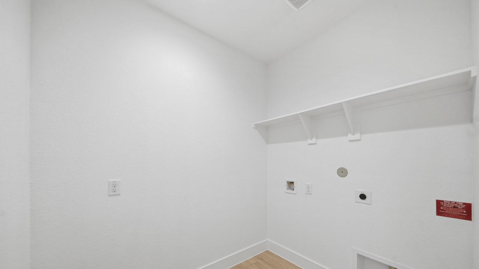 Utility room with storage located off the entry hallway and garage door