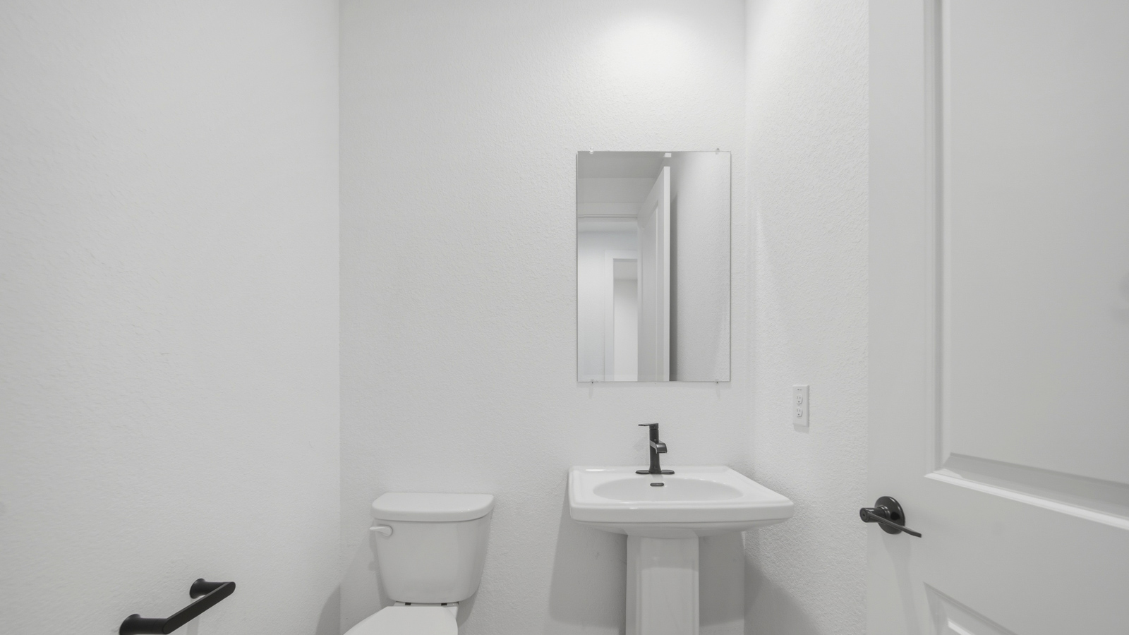 Powder bathroom with pedestal sink right off the foyer entry hallway