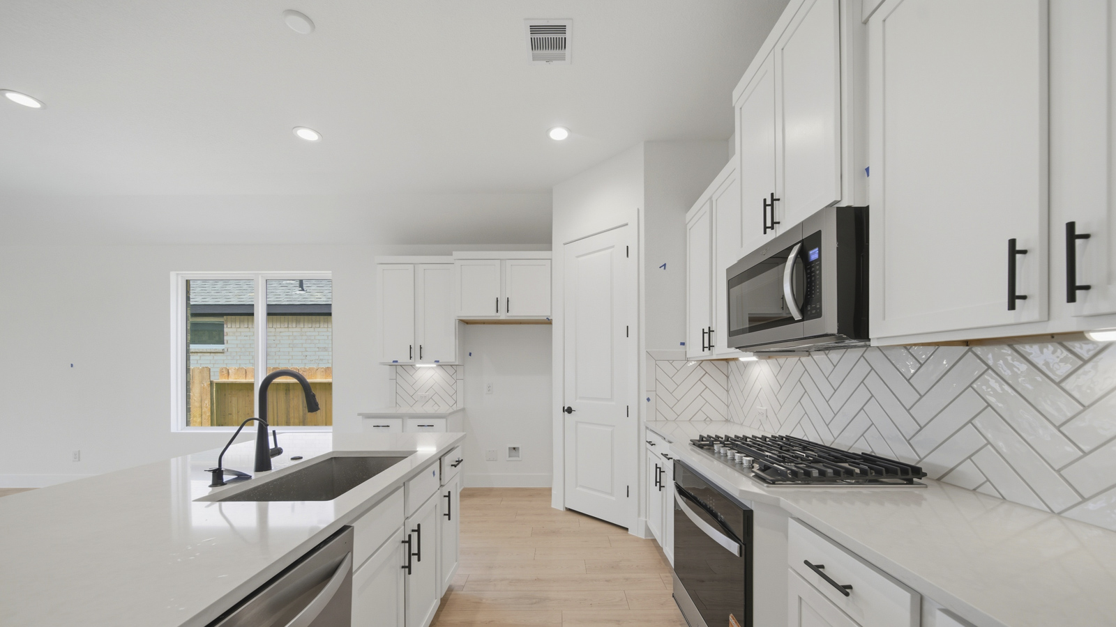 Kitchen with quartz countertops and marden hardware and an island and vinyl floor