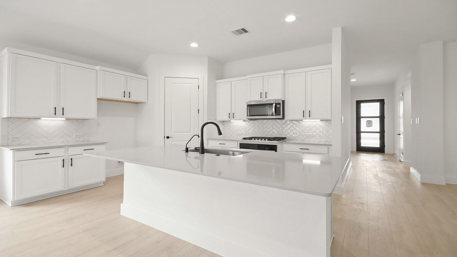 Kitchen with quartz countertops and marden hardware and an island and vinyl floor