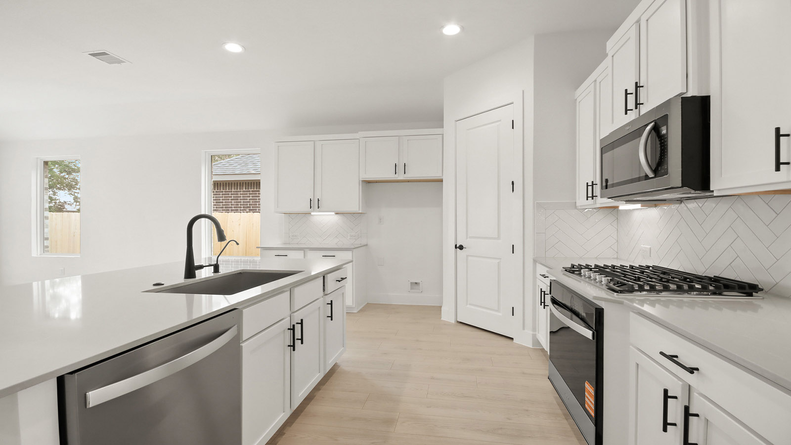 Kitchen with quartz countertops and marden hardware and an island and vinyl floor