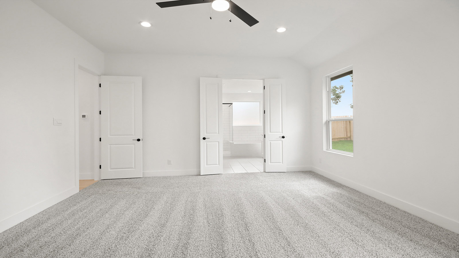 Large Primary bedroom with shag carpet flooring and bright window