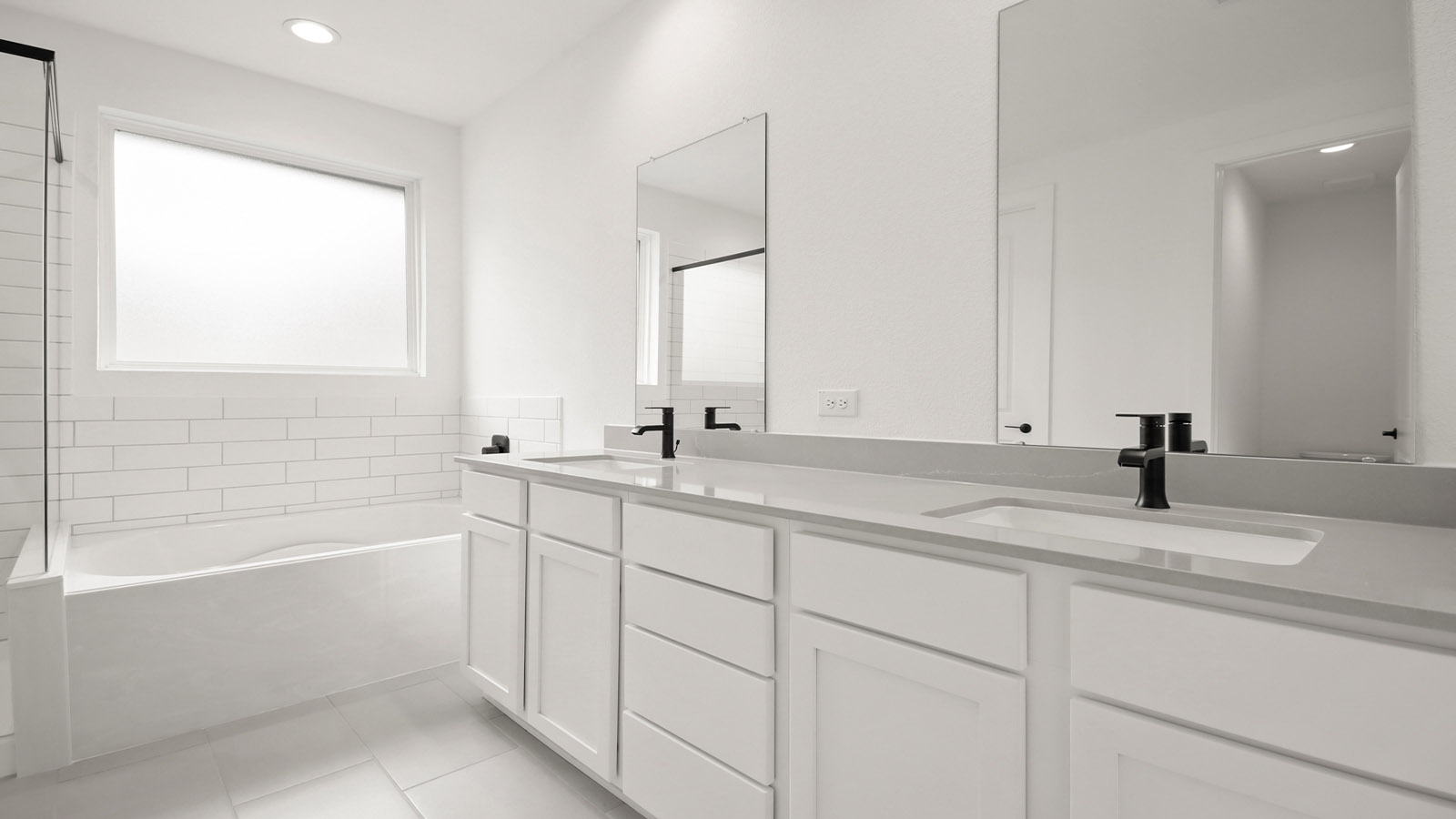 Primary bathroom with double sinks with quartz counter tops in Magnolia TX
