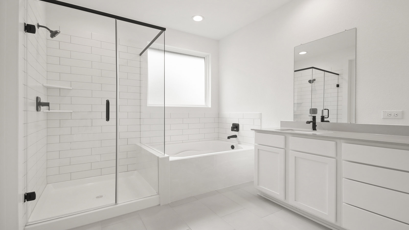 Primary bathroom with soaker tub and tile shower with semi frameless glass in Magnolia TX