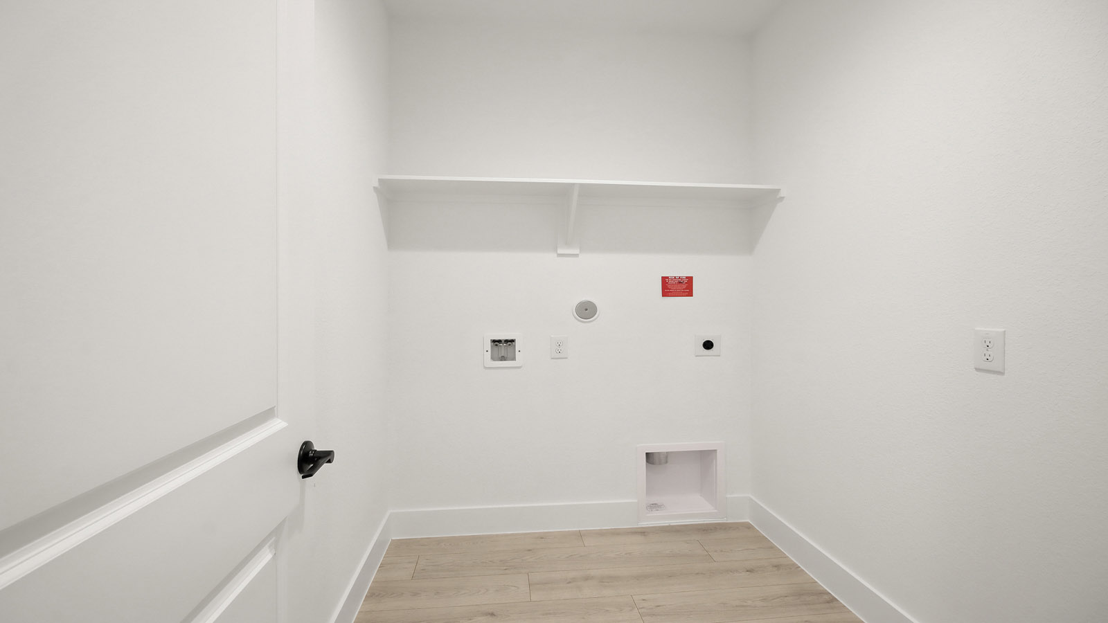 Utility room with storage located off the entry hallway and garage door