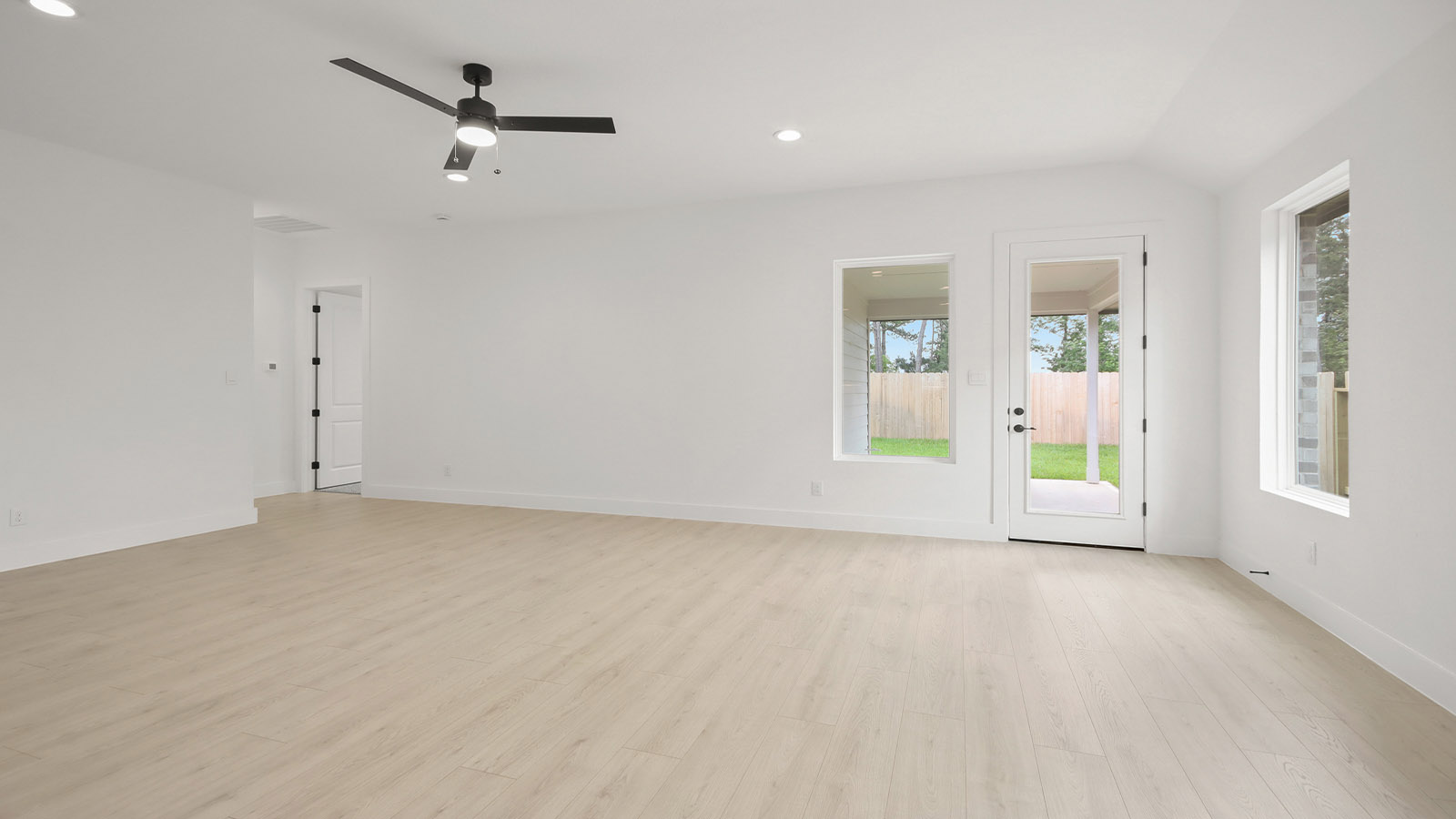 Spacious living area with vinyl flooring and bright windows in Magnolia TX