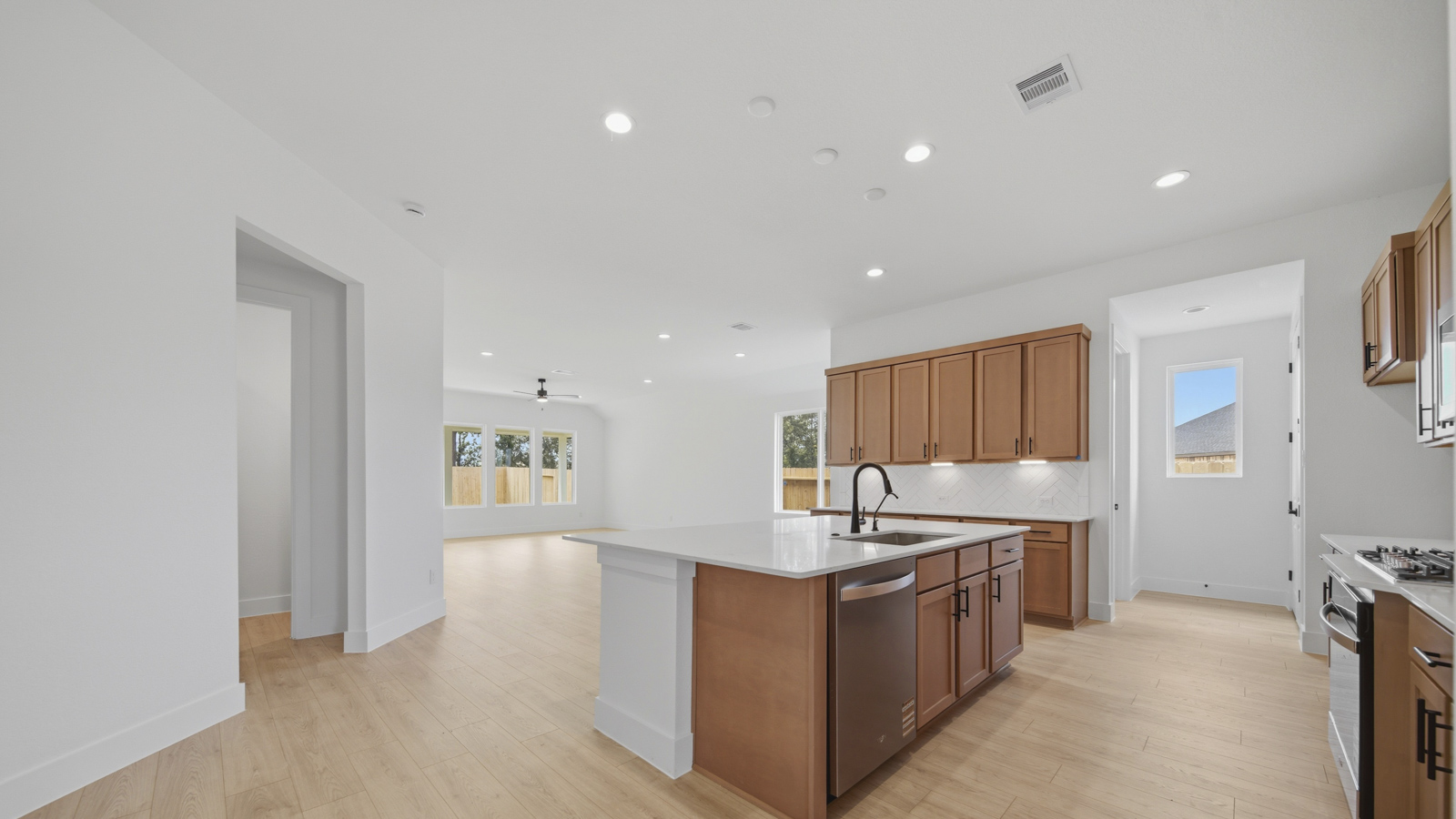 Kitchen with quartz countertops and marden hardware and an island and vinyl floor