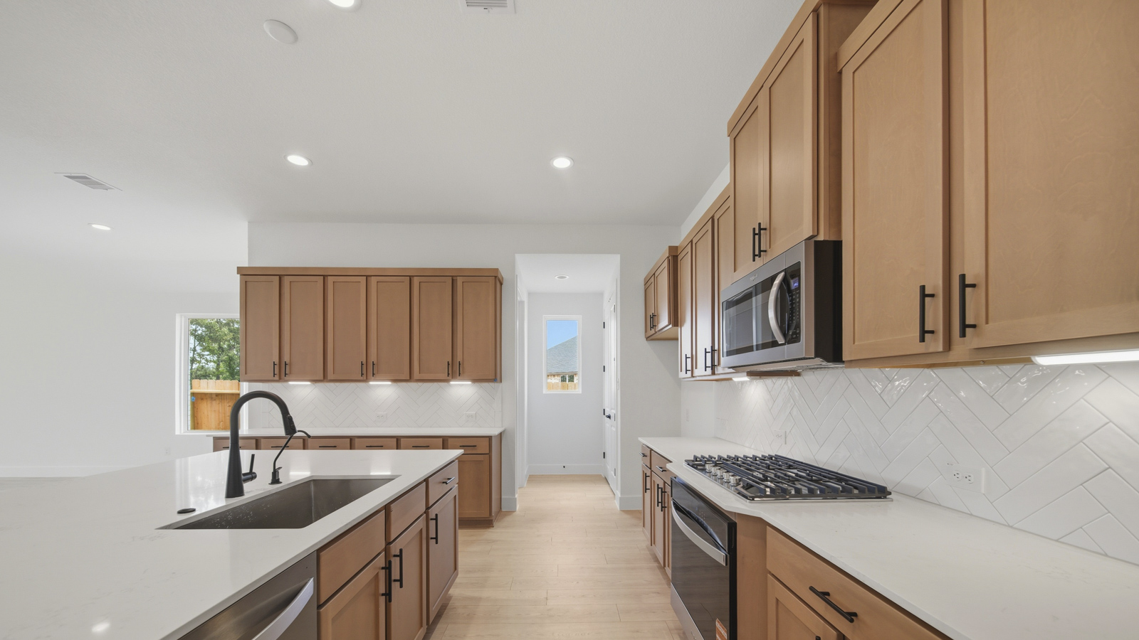 Kitchen with quartz countertops and marden hardware and an island and vinyl floor