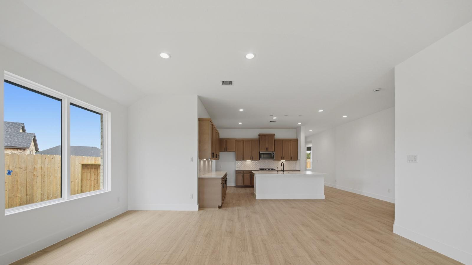 Kitchen with quartz countertops and marden hardware and an island and vinyl floor