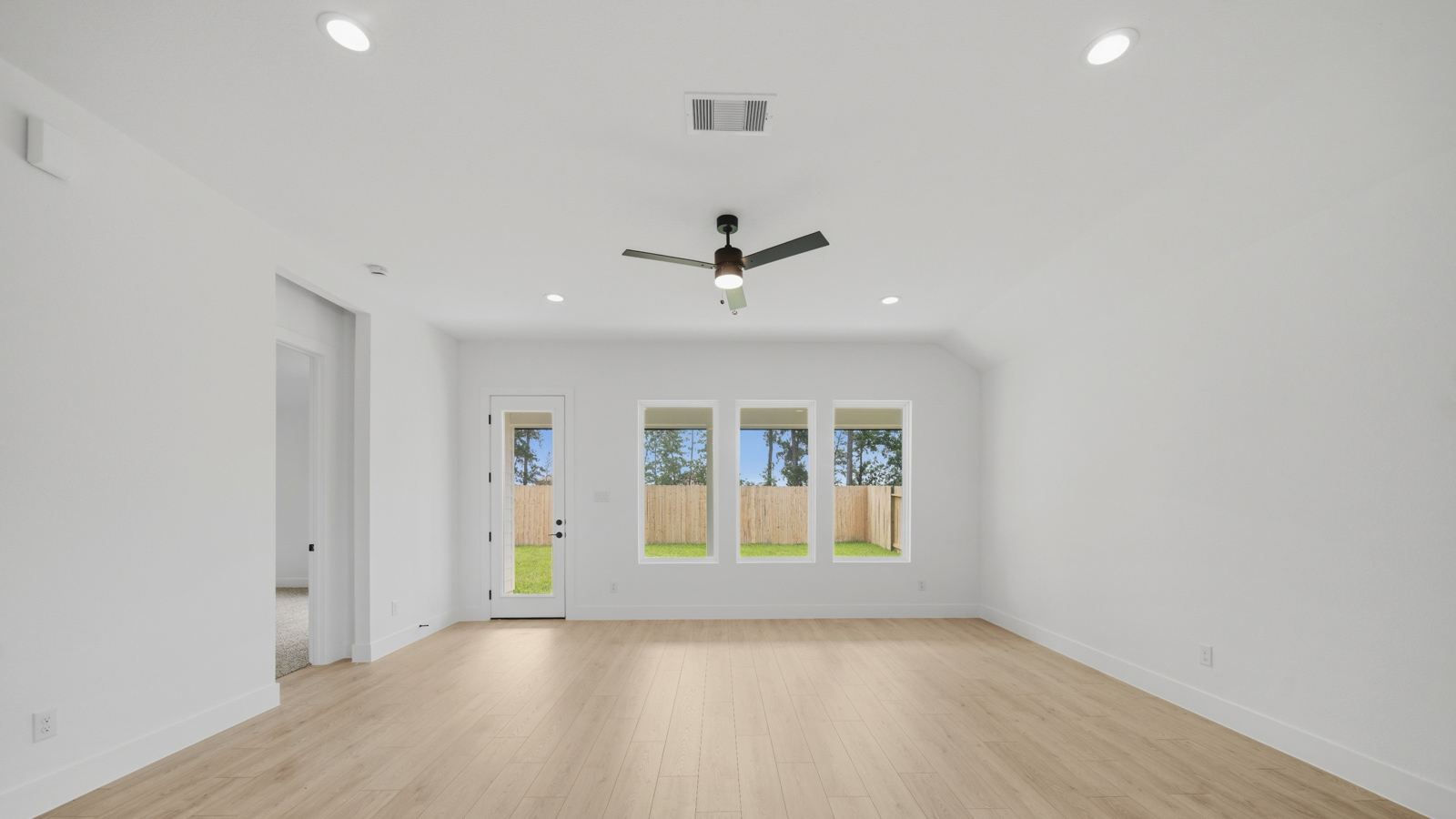 Spacious living area with vinyl flooring and bright windows in Magnolia TX