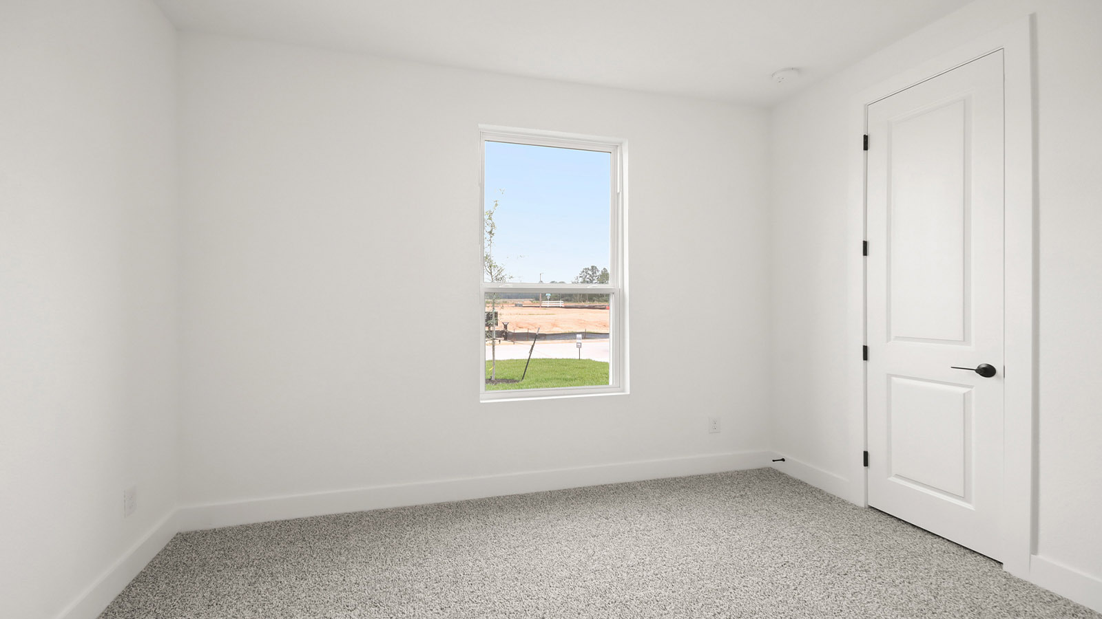 Second level secondary bedroom with carpet flooring and bright window