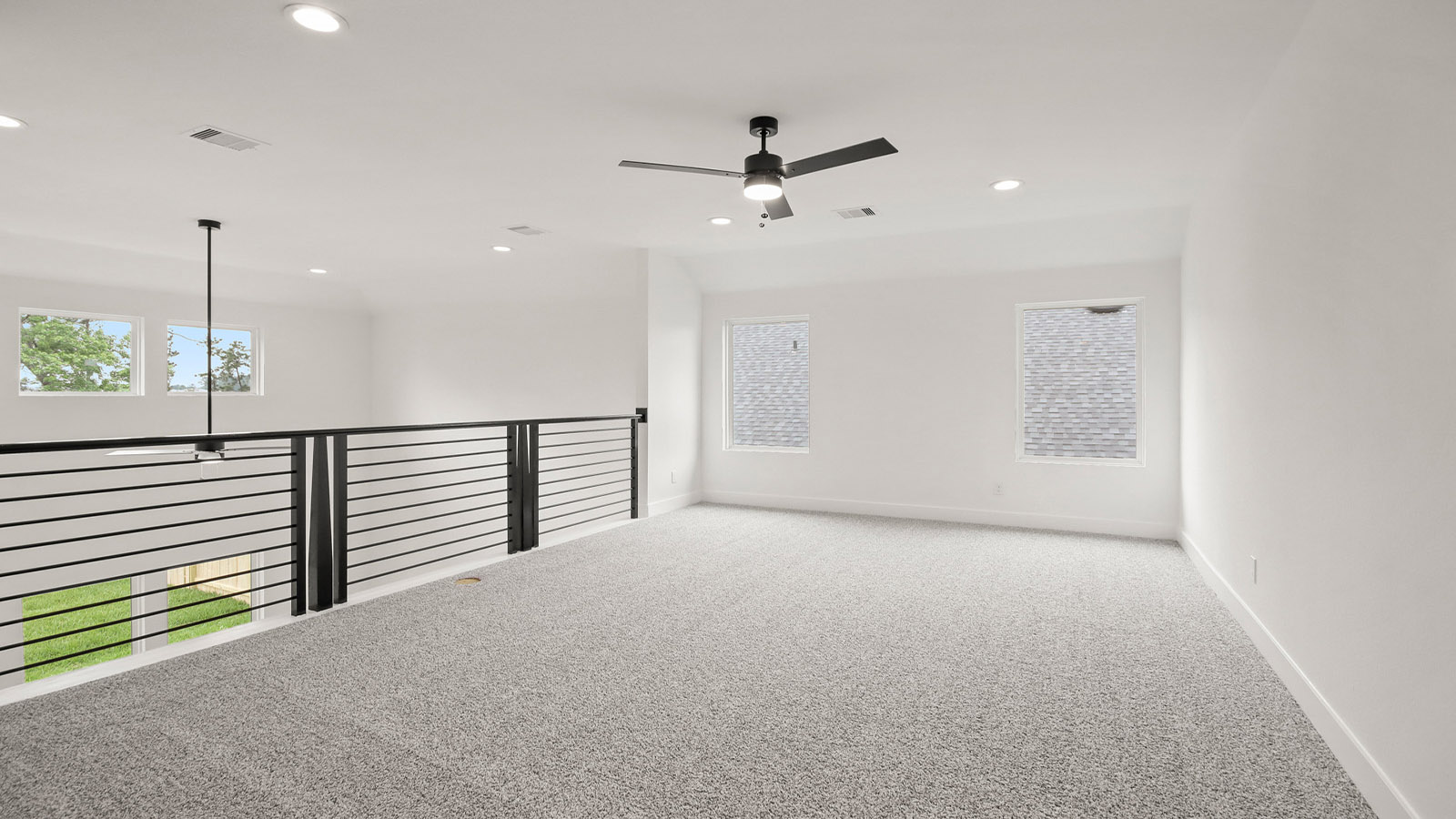 Second story game room with carpet flooring with bright windows in this multi functional space in Magnolia TX