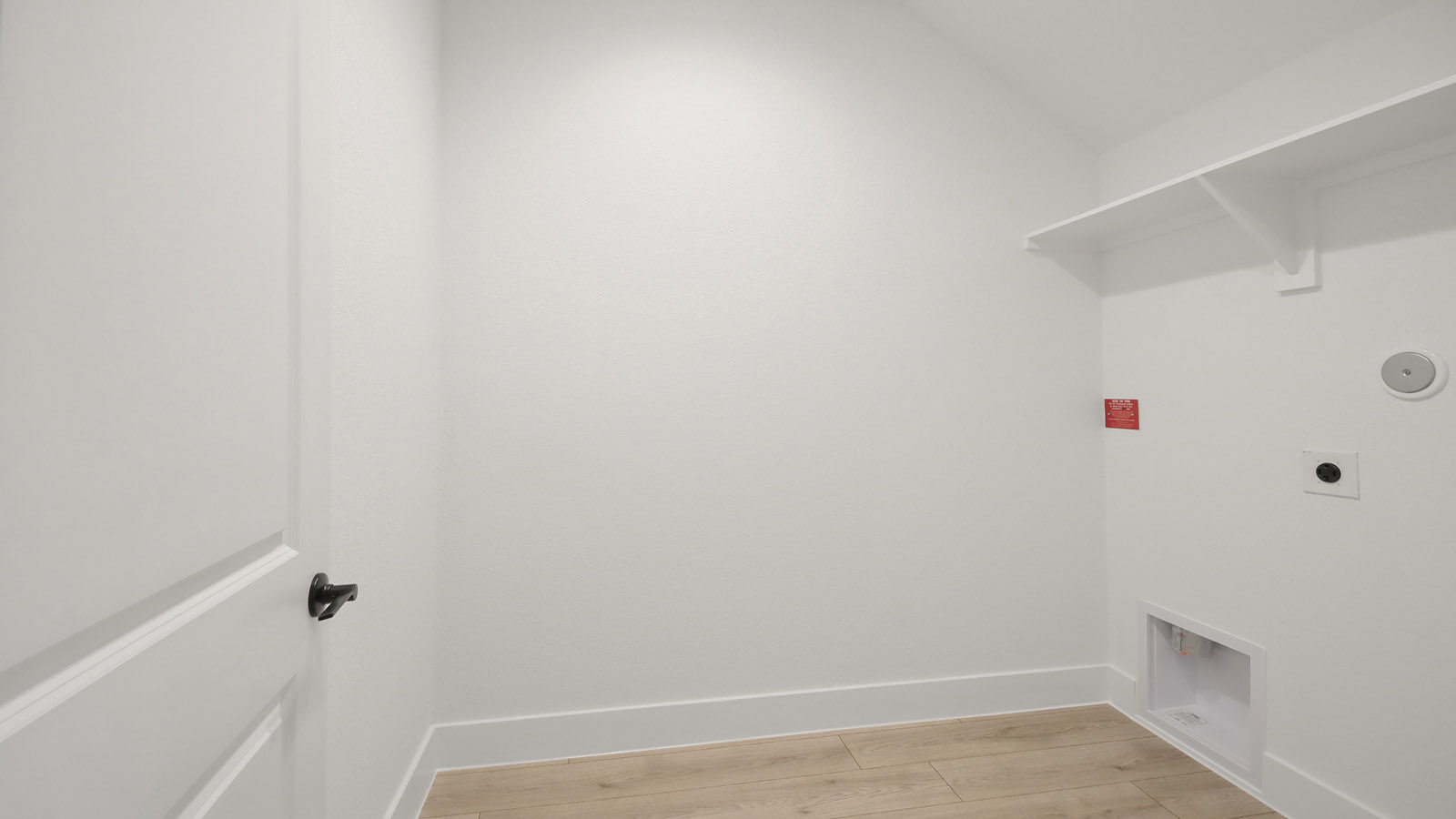 Utility room with storage located off the entry hallway and garage door