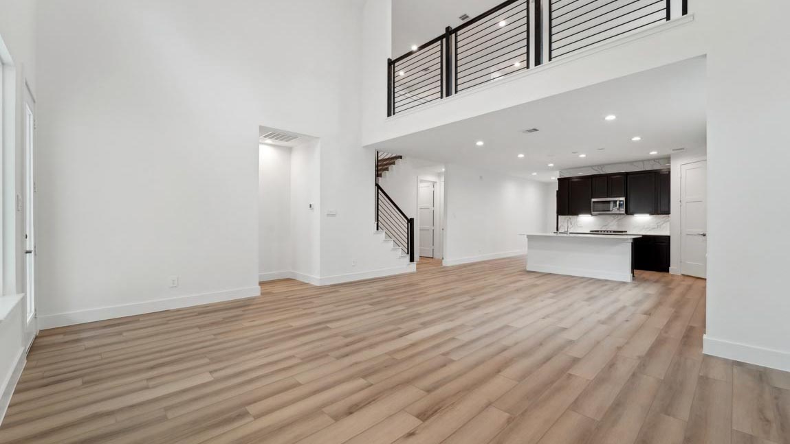 open concept living and dining area with high ceilings, large windows, and vinyl flooring