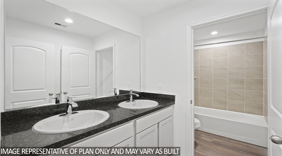 Secondary bathroom with double sink and tub/shower combo.