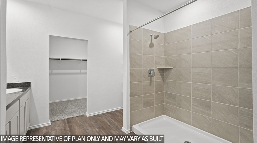 Primary bathroom with standing shower and walk-in closet.