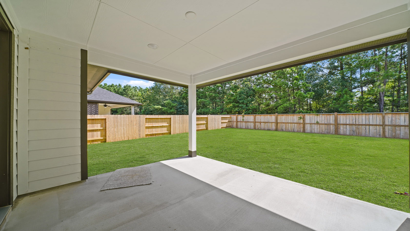 Landscaped backyard with a covered patio.