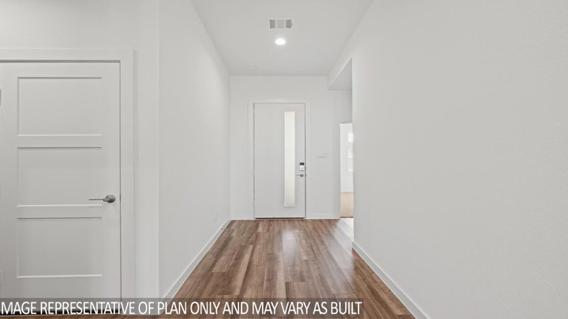 Entry hallway with white walls and vinyl wood flooring.