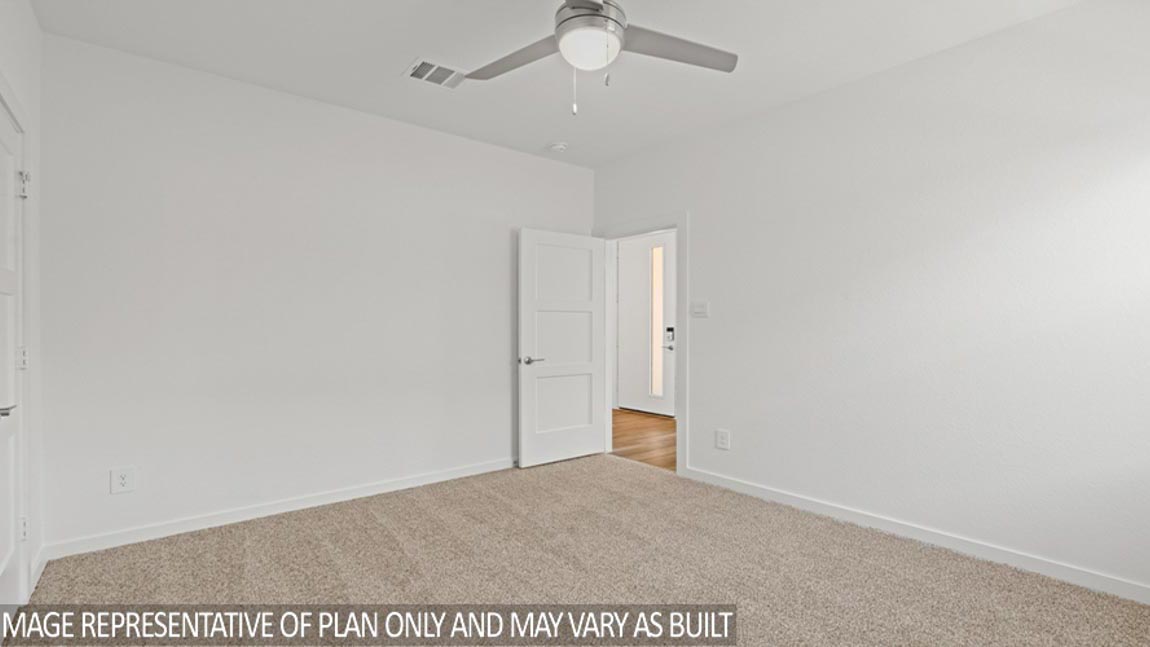Secondary bedroom with carpet flooring, a ceiling fan, and a bright window.