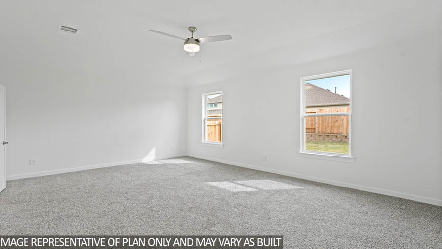 Primary bedroom with windows, white walls, and light carpet.