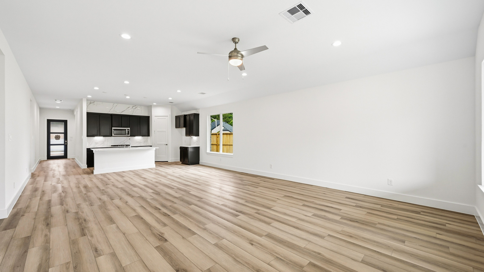 Spacious living area with vinyl flooring