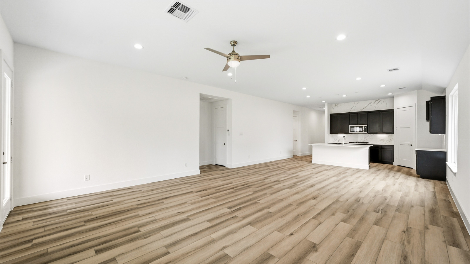 Spacious living area with vinyl flooring