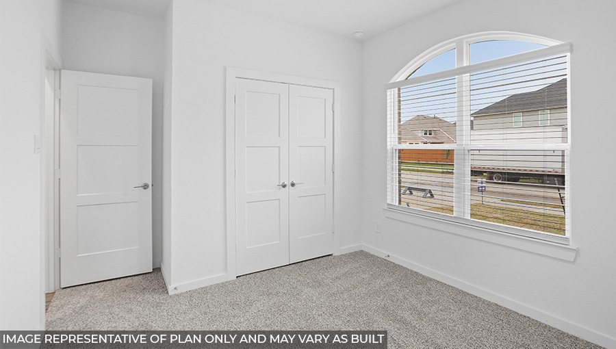 Secondary bedroom with carpet flooring and bright windows.