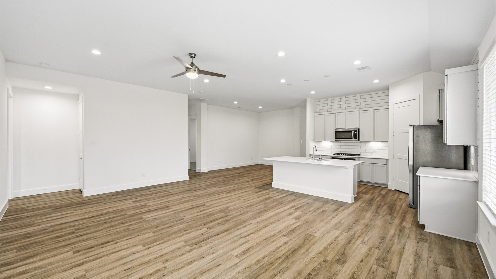 Spacious living area with vinyl flooring