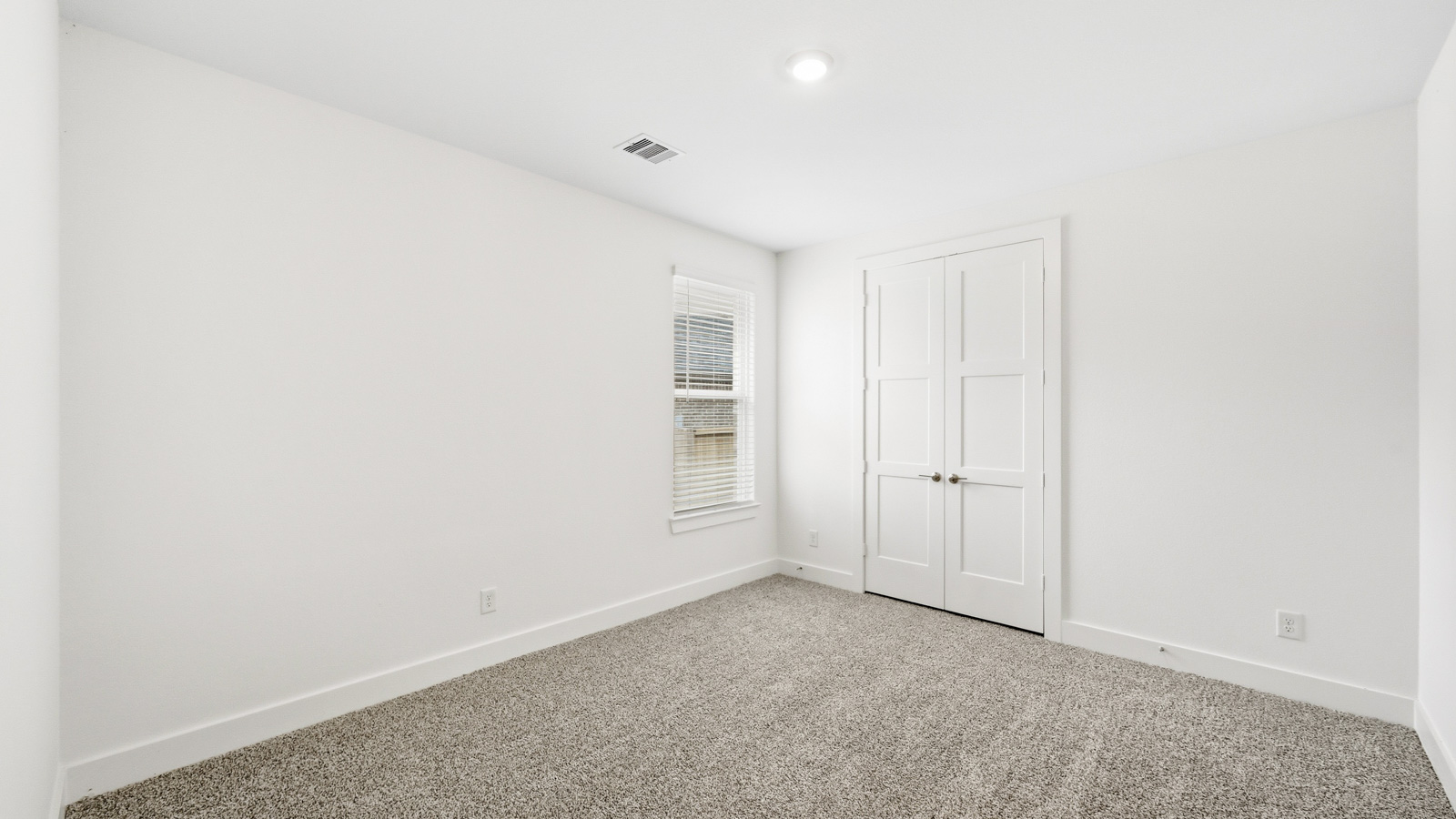 Secondary bedroom with carpet flooring