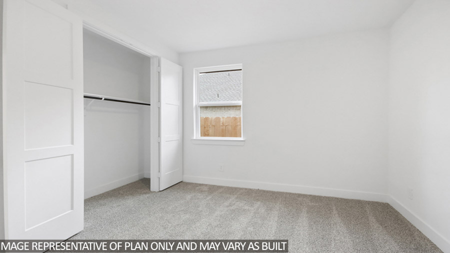 Secondary bedroom with carpet flooring and bright window.