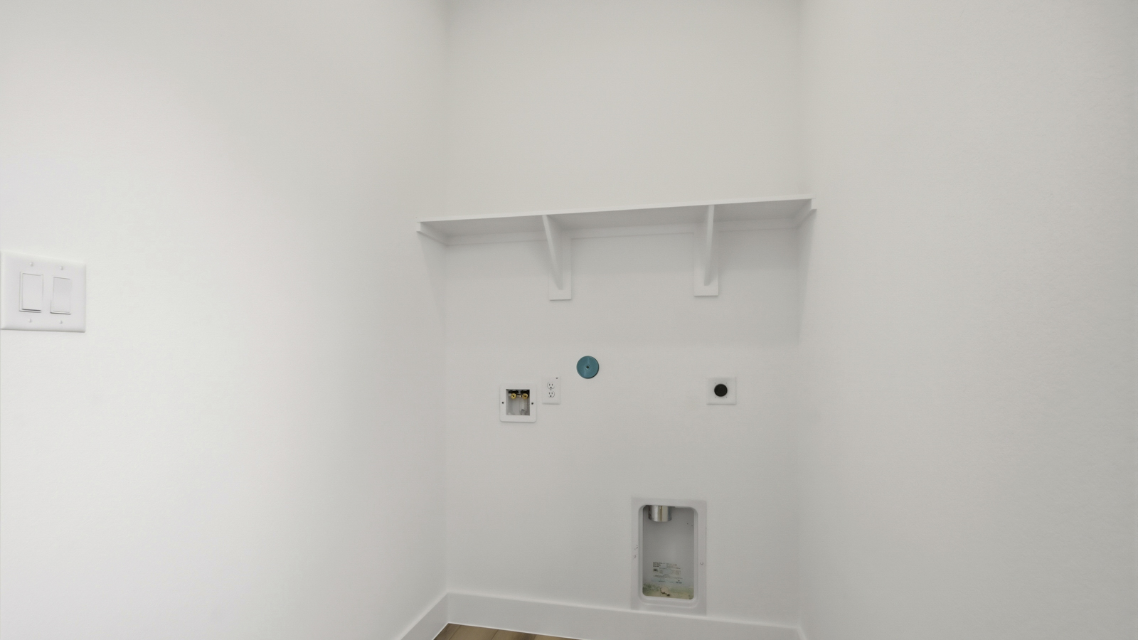 Utility room with storage located off the entry hallway and garage door