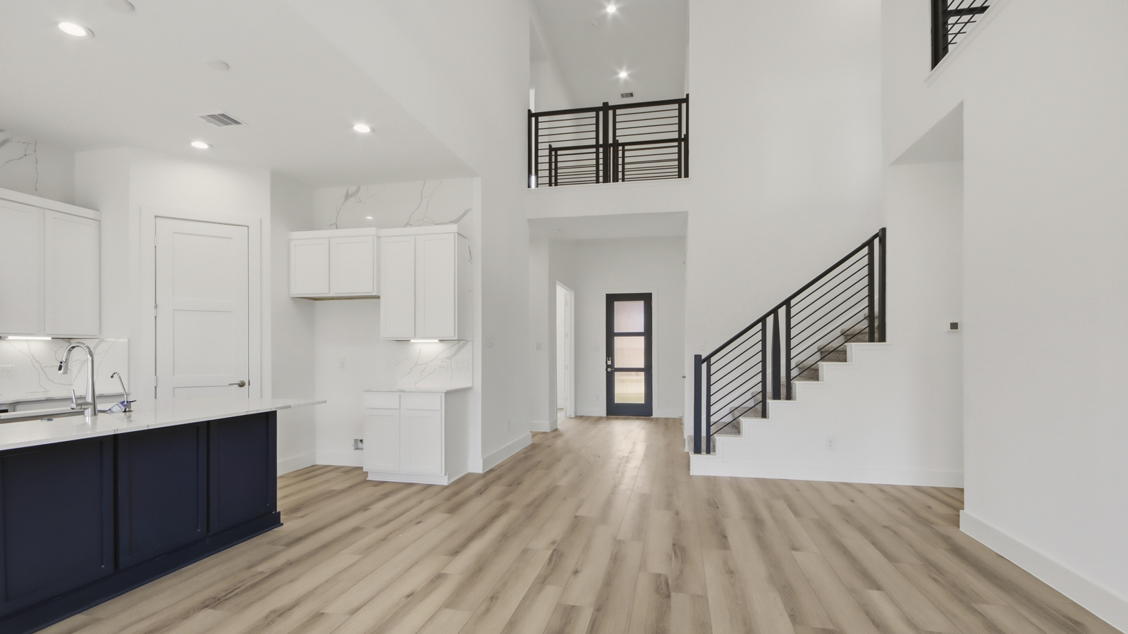 Kitchen with quartz countertops and marden hardware and an island and vinyl floor