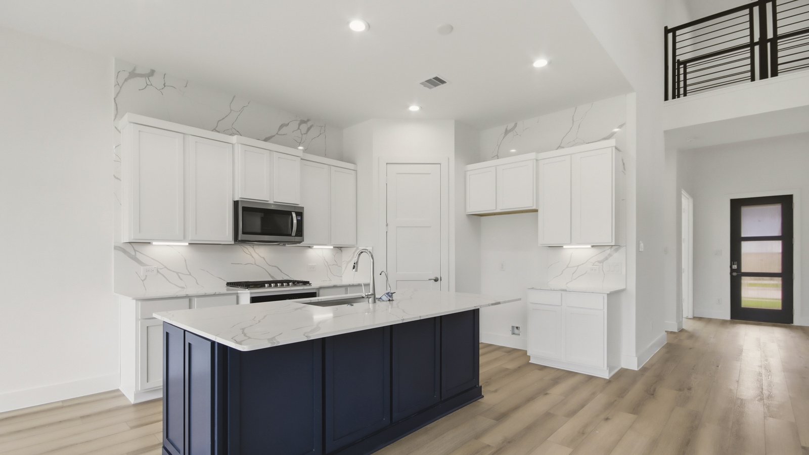 Kitchen with quartz countertops and marden hardware and an island and vinyl floor