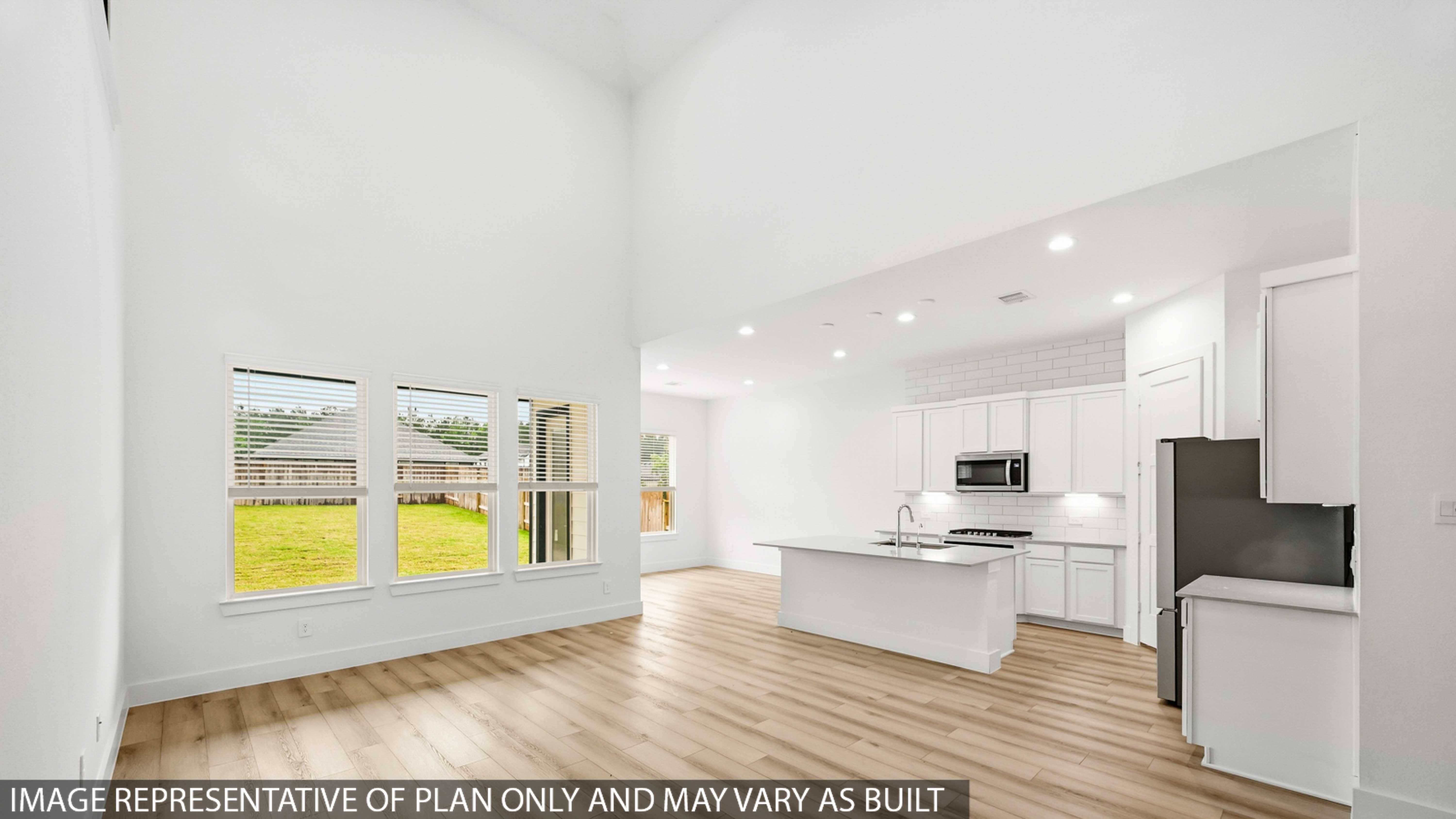 Kitchen with stainless steel appliances, quartz countertops and modern hardware and an island and vinyl floor