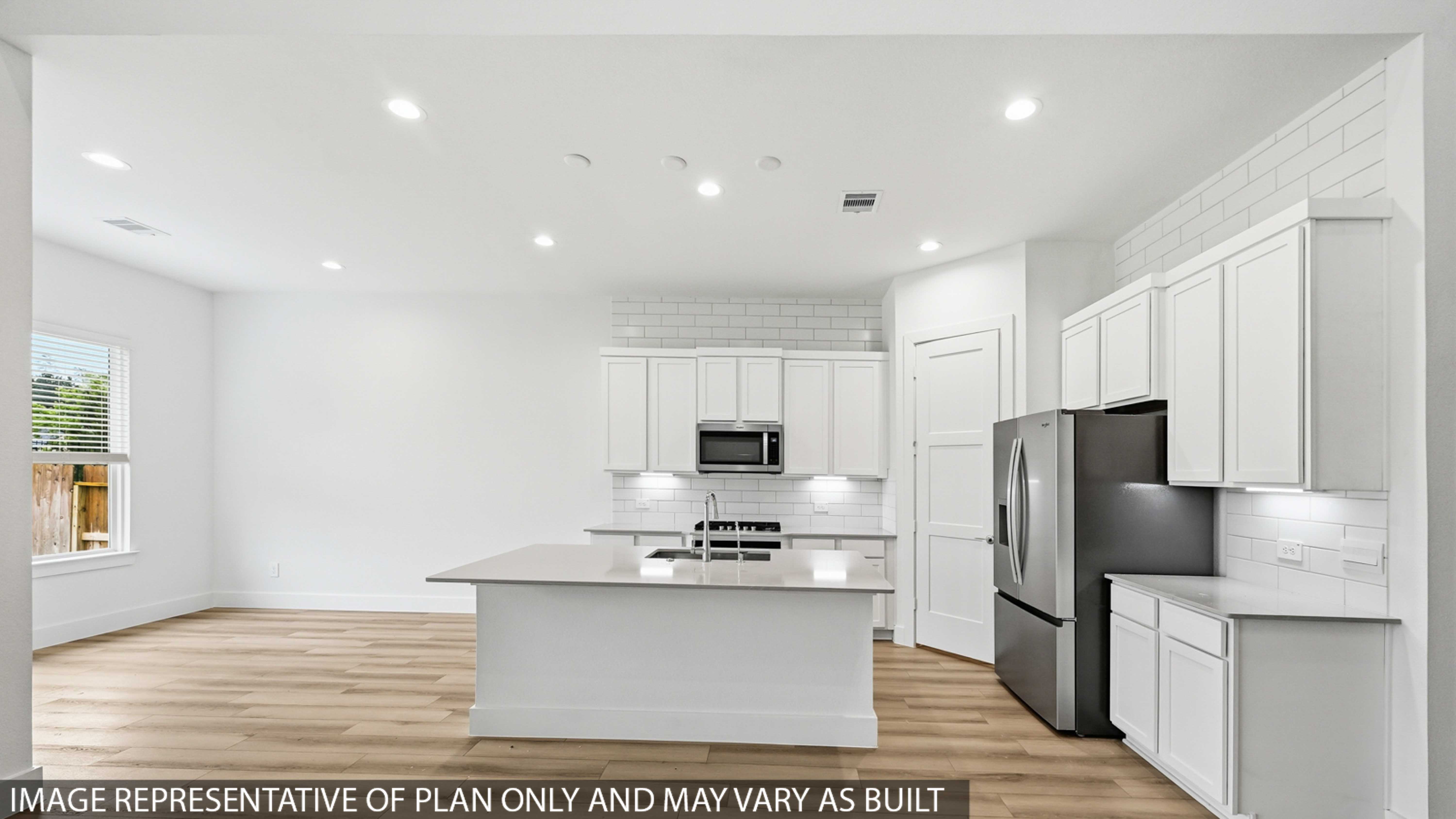 Kitchen with stainless steel appliances, quartz countertops and modern hardware and an island and vinyl floor