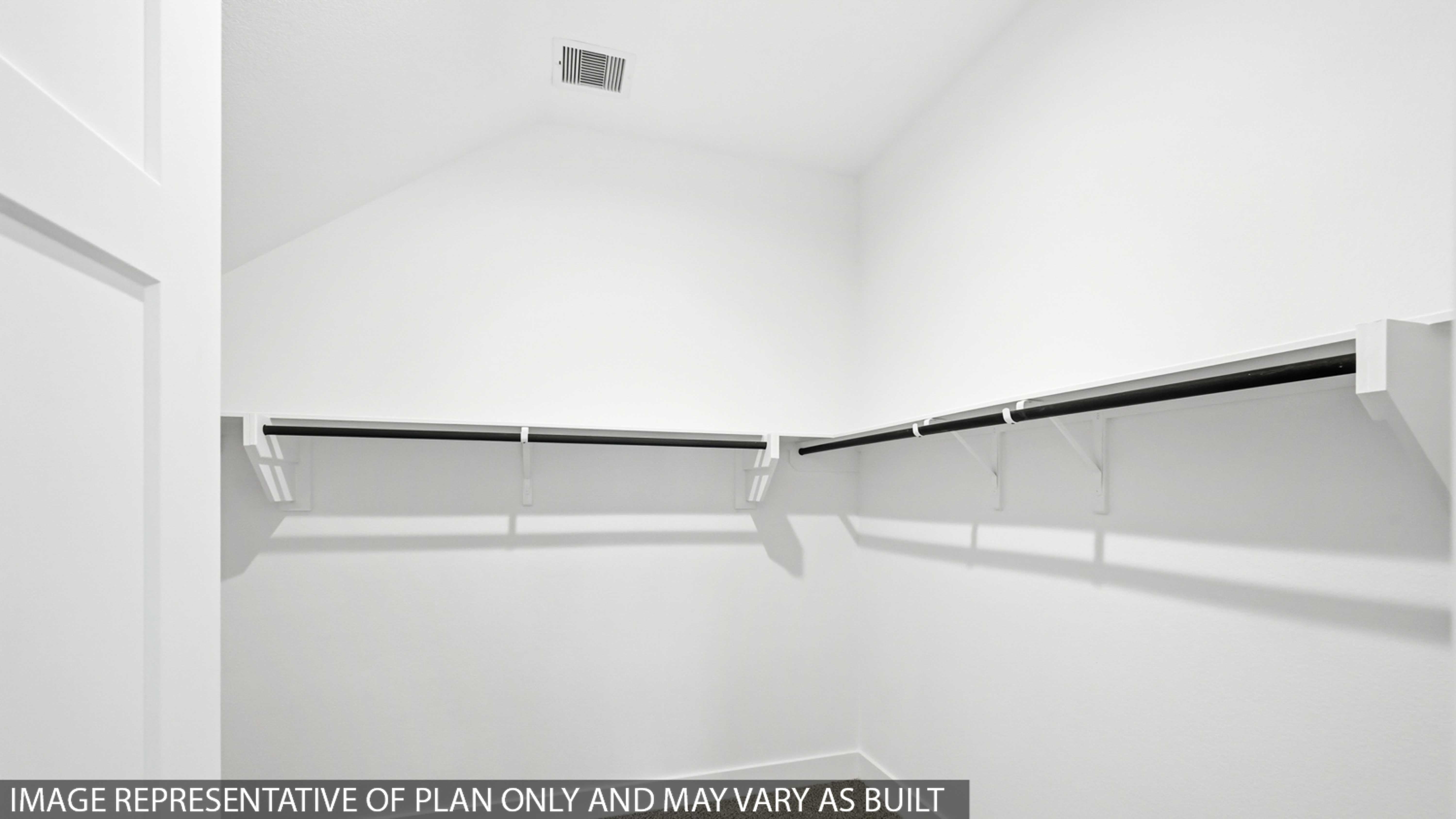 Primary bedroom walk-in closet with carpet flooring in Chapel Lakes community in Montgomery TX