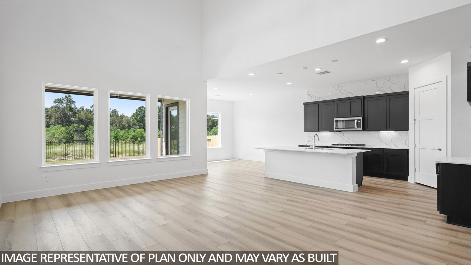 Open living room with windows, white walls, and vinyl wood flooring.