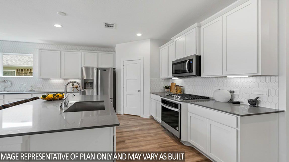 Open kitchen with an island, stainless steel appliances, white cabinets, white walls, and vinyl wood flooring.