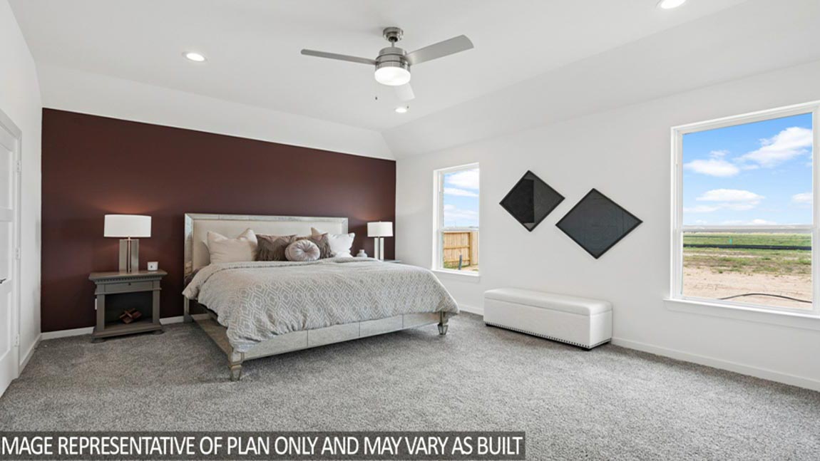 Primary bedroom with windows, white walls, and light carpet.