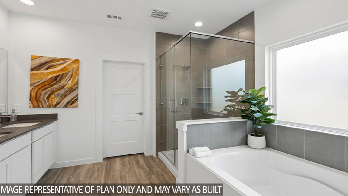 Primary bathroom with dual sinks, shower, tub, white walls, and vinyl wood flooring.
