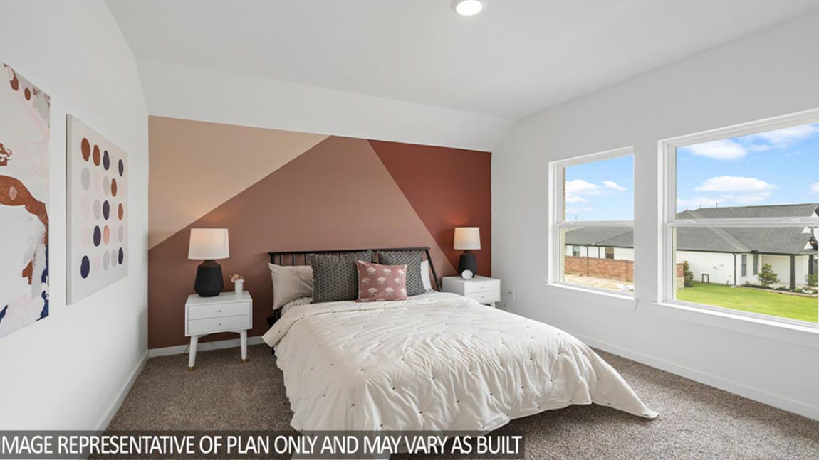Secondary bedroom with windows, white walls, and light carpet.
