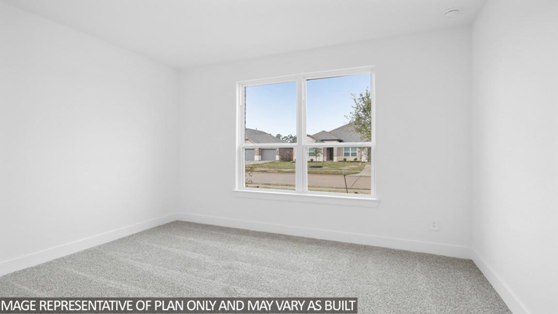 Secondary bedroom with carpet flooring and bright window.