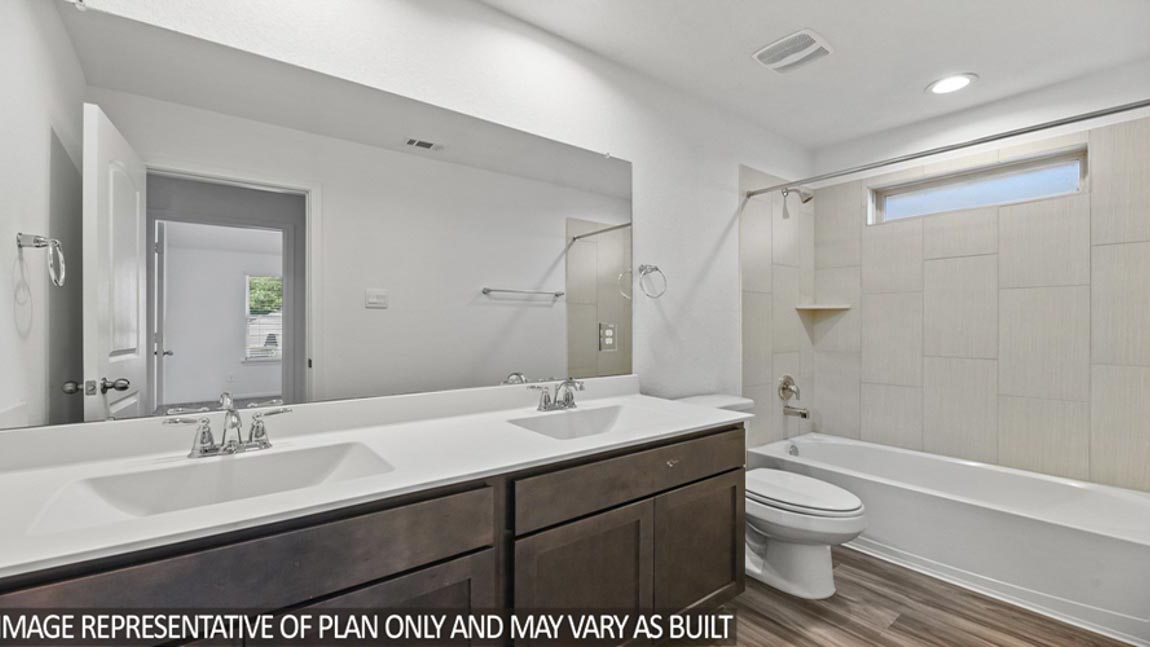Secondary bathroom with a double sink and a tile tub/shower combo.