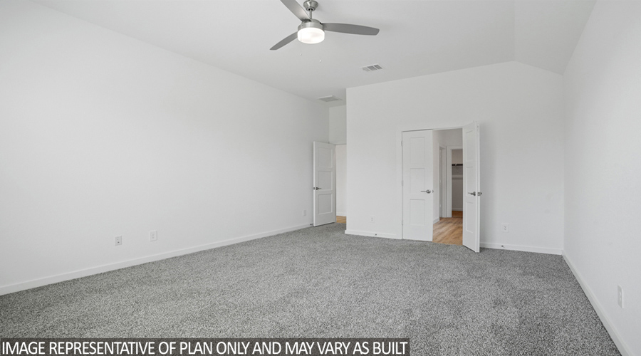 Primary bedroom with carpet flooring and bright windows.