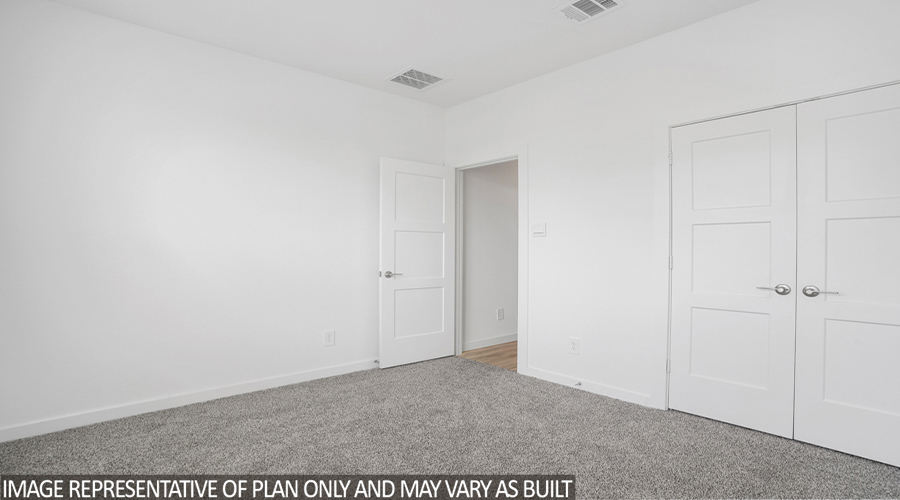 Secondary bedroom with carpet flooring.