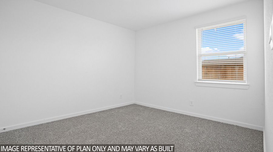 Secondary bedroom with carpet flooring and bright window.