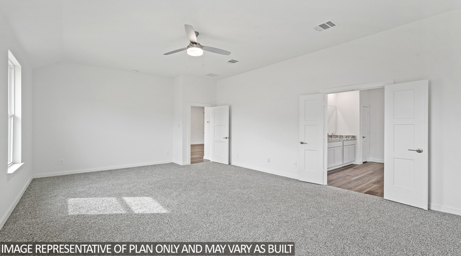 Primary bedroom with carpet flooring and two bright windows.