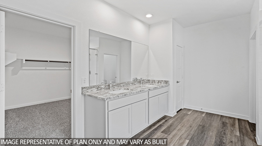 Primary bathroom with vinyl flooring and double sink.