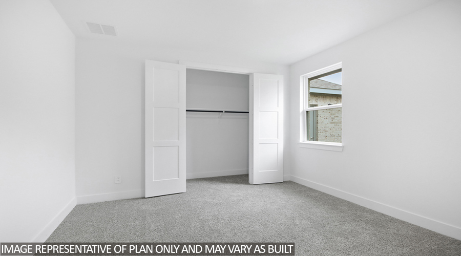 Secondary bedroom with carpet flooring and tall closet.